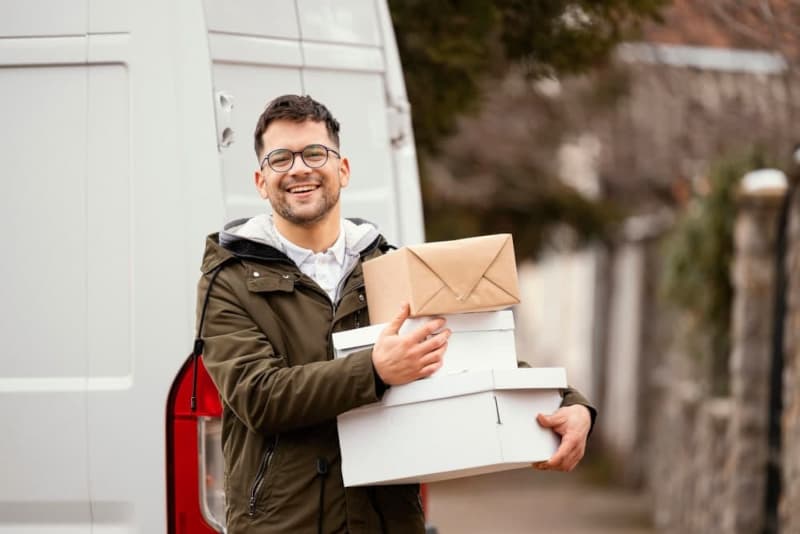 Smiling van driver holding boxes